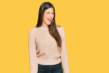 Canvas Print - Young brunette woman wearing casual winter sweater winking looking at the camera with sexy expression, cheerful and happy face.