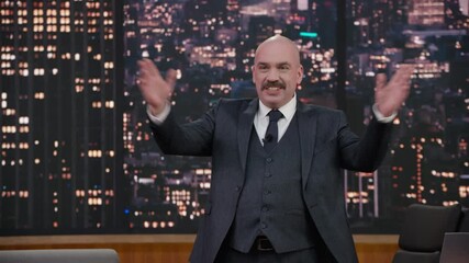 Wall Mural - ZOOM IN Late-night talk show host entering studio, greeting audience and performing his monologue, looking into camera. TV broadcast style show. Shot with RED cinema camera