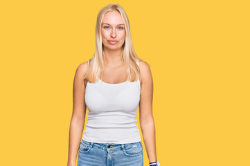 Sticker - Young blonde girl wearing casual style with sleeveless shirt looking sleepy and tired, exhausted for fatigue and hangover, lazy eyes in the morning.