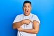 © Krakenimages.com - Young latin man using glucose meter button on arm celebrating crazy and amazed for success with open eyes screaming excited.