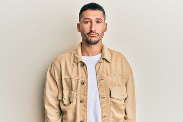 Canvas Print - Handsome man with tattoos wearing casual brown denim jacket depressed and worry for distress, crying angry and afraid. sad expression.