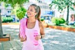 © Krakenimages.com - Middle age sportswoman smiling happy holding bottle of water at the park