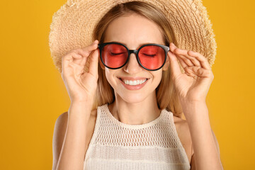 Canvas Print - Beautiful woman in stylish sunglasses on yellow background