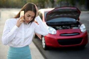 Wall Mural - Stressed woman talking on phone near broken car outdoors