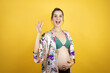 © Irene - Young beautiful woman pregnant expecting baby wearing pajama over isolated yellow background showing and pointing up with fingers number four while smiling confident and happy
