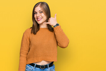 Beautiful caucasian woman wearing casual clothes smiling doing phone gesture with hand and fingers like talking on the telephone. communicating concepts.