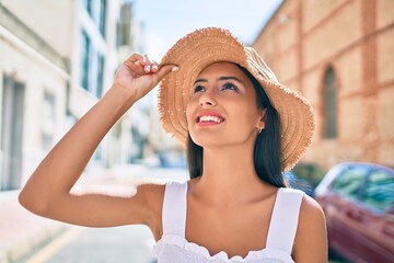 Poster - Young latin girl wearing summer style and smiling happy at street of city.