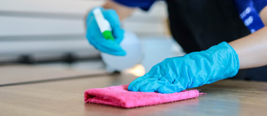 Male employees are cleaning restaurant tables, cleaning to prevent transmission of COVID-19, COVID-19 prevention concept.