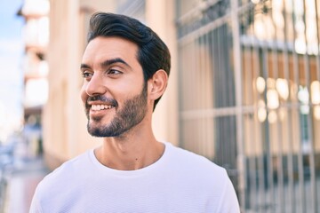 Sticker - Young hispanic man smiling happy walking at the city.