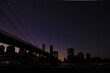 Brooklyn bridge and lower manhattan at night after sunset with colorful skies