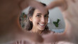 Close up portrait emotional smiling millennial woman showing heart sign to camera, sending love feelings. Happy young lady making love gesture, enjoying online dating or distant communication.