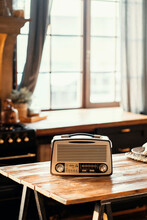 Cozy Kitchen Playing Classical Music. Vintage Radio Player Stands On A Wooden Table In A Bright Apartment. Daylight From The Window Illuminates The Room.