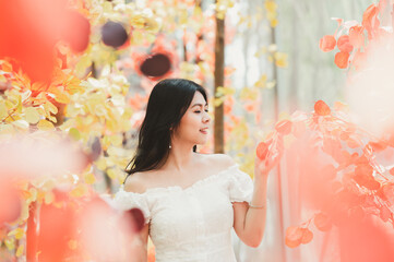 Portrait of happy beautiful Asian woman  in a white dress in autumn. warm sunny weather fall concept