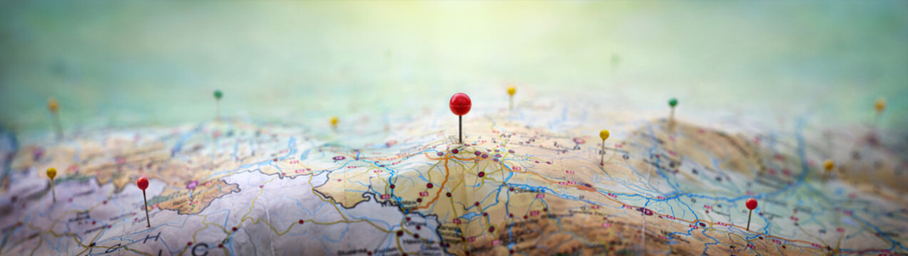 pins on a geographic map curved like mountains. pinning a location on a map with mountains. adventur