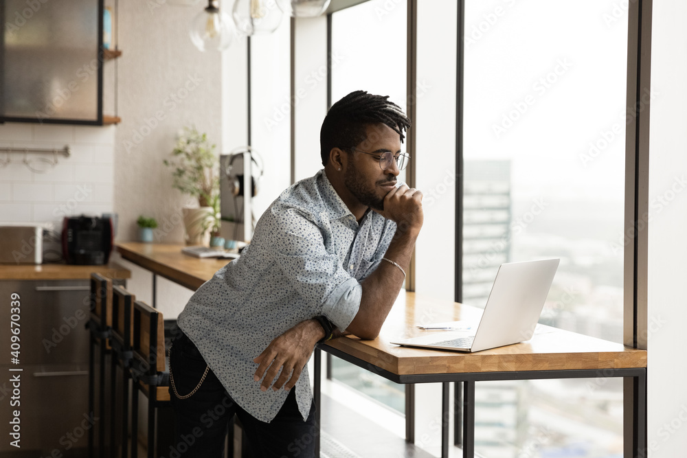 I need to think a little. Concentrated young black male ponder before pc screen at modern studio make important choice decision. Focused afro american guy study data or web search result using laptop - obrazy, fototapety, plakaty 