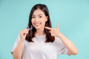 Dental Beautiful smiling of young asian woman with retainer braces glad emotion with white teeth increase confidence for healthy on blue background isolated, Happiness teenager facial expression.