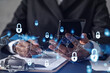 © VideoFlow - African American businesswoman in formal wear signing the contract to prevent probability of risks in cyber security. Checking the phone. Padlock Hologram icons over the working desk.