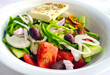 Greek Nicosia salad on a plate with feta cheese, olives, tomatoes and other fresh vegetables. 