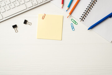 Flatlay above overhead close up frame border view photo of colorful pencils pen sheets of note paper open diary pc items isolated white wooden backdrop with blank empty space