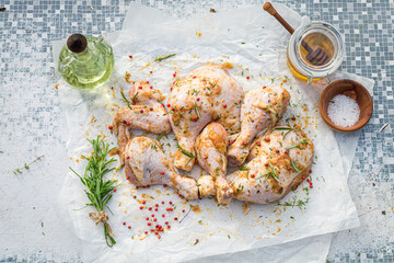 Seasoning raw chicken legs with honey, salt and herbs