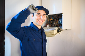 Wall Mural - Smiling technician repairing an hot-water heater