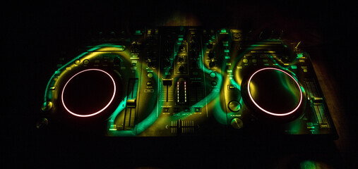 Wall Mural - DJ console deejay-mixing desk in dark with colorful light. Mixer equipment entertainment DJ station.