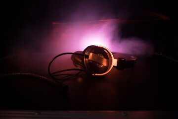 Wall Mural - Dj music club concept. Close up headphones on dark background with colorful light.