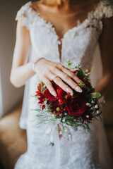 Wall Mural - Vertical shot of the bride's hand showing her wedding ring and holding her hand on the bouque