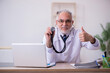 © Elnur - Old male doctor working in the clinic