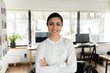 Confident Indian millennial businesswoman posing with hands folded in office. Head shot portrait of happy young female professional, business leader, boss or corporate coach looking at camera.