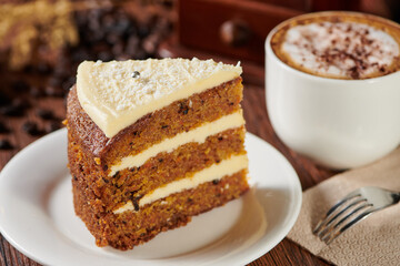 Poster - Slice of carcake on a plate with a cappuccino on a wooden table