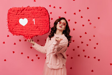 Wall Mural - Ginger girl posing with hearts on background. Wonderful young woman enjoying valentine's day decoration.