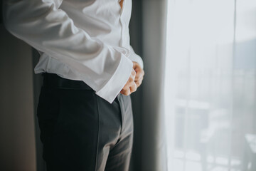 Sticker - Closeup shot of male hands tying his belt - wedding preparation