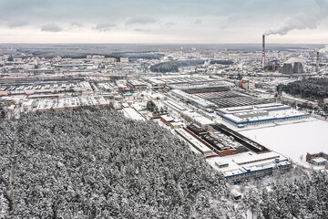 Wall Mural - urban industrial area in winter. factory buildings, warehouses and thermal power plant on overcast sky background. aerial view