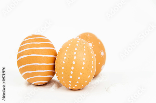 Close-up of three eggs with a minimalist pattern on a white background. The concept of Easter eggs in eco style. © nadezhda