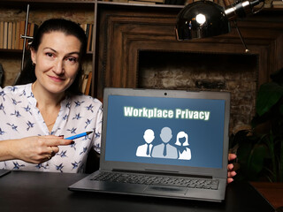 Wall Mural - Woman wearing blue business suit and showing laptop with written text Workplace Privacy .