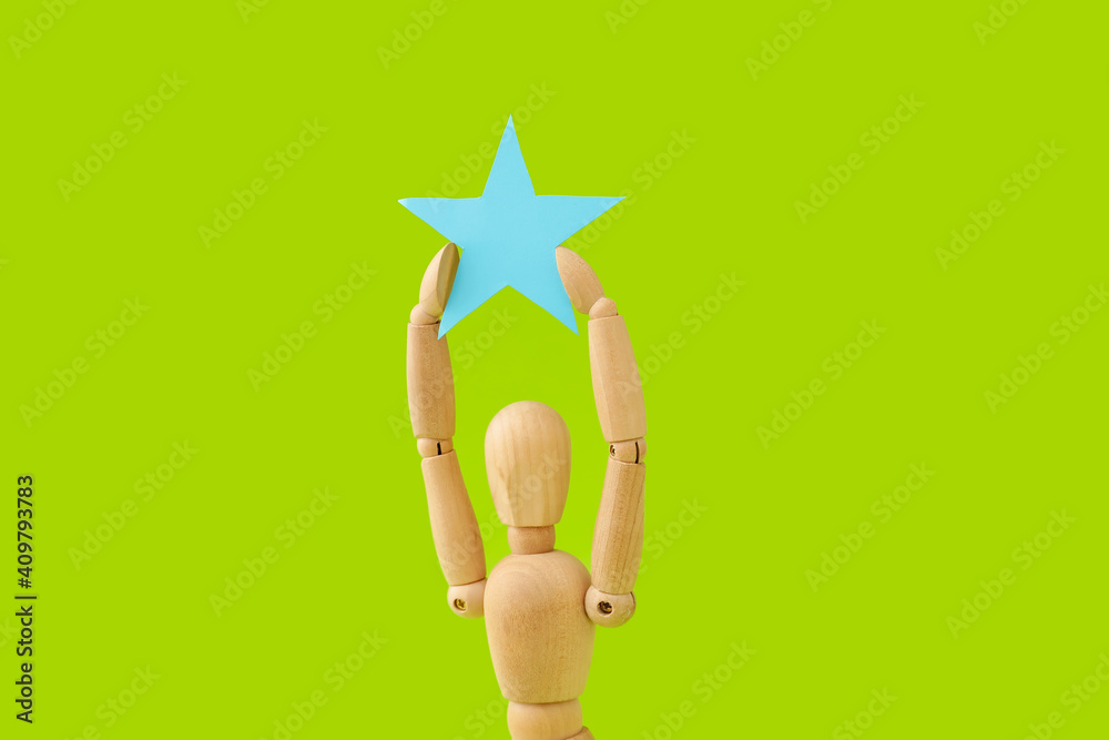 Wooden mannequin with star on color background