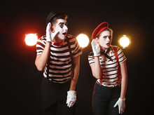 Male And Female Pantomimists On Dark Background
