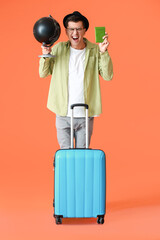 Sticker - Stressed male tourist with globe and luggage on color background