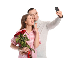 Wall Mural - Happy engaged couple taking selfie on white background