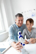 © epiximages - Family and childhood concept. Dad and son have fun together playing with a robot.