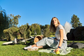 Young beautiful woman sitting on the grass in the park