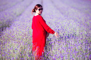 Wall Mural - The Asian woman wearing red dress in a lavender field,beautiful lavender flowers blooming in the garden.