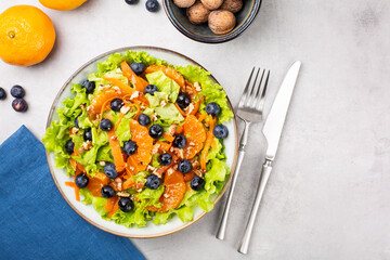 Wall Mural - Fresh salad with blueberries, tangerines, carrots and walnuts.