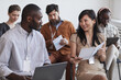 © Seventyfour - Multi-ethnic group of people in audience at business conference focus on smiling man and woman talking while sitting on chairs in row