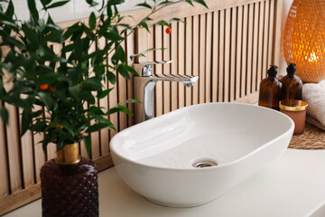 Poster - Vase with beautiful branches and candles near vessel sink in bathroom. Interior design