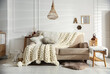 © New Africa - Cozy living room interior with beige sofa, knitted blanket and cushions