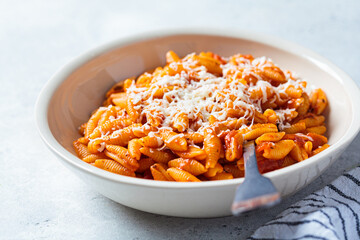 Canvas Print - Gnocchetti sardi pasta in tomato sauce with cheese, gray background. Italian pasta concept