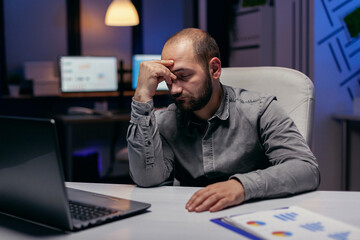 Poster - Overworked businessman sleeping resting his head on his hand. Workaholic employee falling asleep because of working late at night alone in the office for important company project.