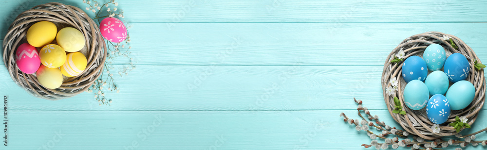 Flat lay composition with colorful Easter eggs on light blue wooden table, space for text. Horizontal banner design - obrazy, fototapety, plakaty 